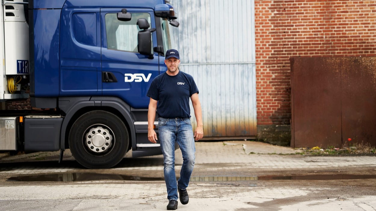 DSV sjåfør går langs lastebil.